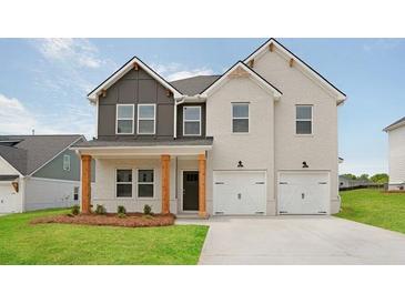 Charming two-story home boasts a painted brick facade, complemented by a two-car garage and a well-manicured lawn at 342 Orwell Drive Lot 95, Social Circle, GA 30025
