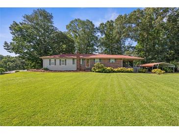 Charming single-story home features a well-manicured lawn, mature trees, and a convenient carport at 6674 Cowan Mill Rd, Winston, GA 30187