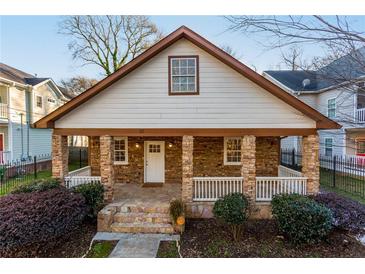 Charming home featuring a stone facade, covered porch with stone pillars, and manicured landscaping at 83 Ormond Se St, Atlanta, GA 30315