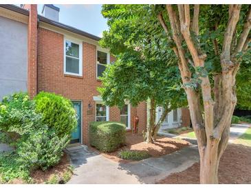 Charming townhome with brick facade, mature landscaping, and inviting blue front door at 4177 Elder Ln, Duluth, GA 30096