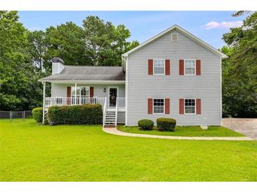 Charming two-story home with a well-manicured lawn, inviting curb appeal and a covered front porch at 1876 Kathy Ct, Douglasville, GA 30135