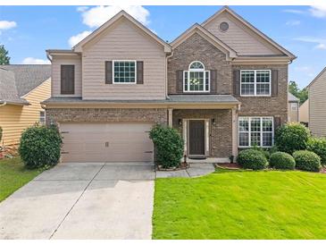 Charming two-story home featuring a well-manicured lawn, a two-car garage, and a welcoming front porch at 1786 Jameson Cir, Lawrenceville, GA 30043