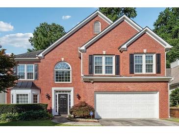 Charming two-story brick home with a well-manicured lawn and attached two car garage at 3272 Monarch Pine Dr, Peachtree Corners, GA 30071