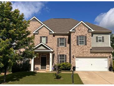 Charming two-story brick home with a well-manicured lawn and attached two-car garage in a suburban neighborhood at 4752 Albany Way, South Fulton, GA 30331