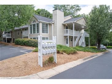 Exterior of a two-story home with off white siding, a chimney, landscaping, and mailboxes out front at 1910 Countryside Se Pl, Smyrna, GA 30080