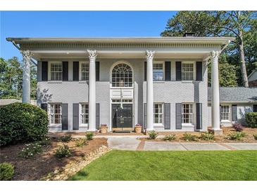 Stately two-story home with gray brick, black shutters, and prominent white columns at 6300 Blackwater Trl, Atlanta, GA 30328