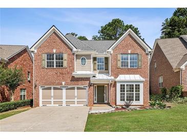 Charming two-story brick home featuring a well-manicured lawn and a two-car garage at 2761 Valley Spring Dr, Lawrenceville, GA 30044