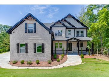 Beautiful two-story home with a stone facade, black accents, and a well-manicured front yard at 4208 Sierra Creek Ct, Hoschton, GA 30548