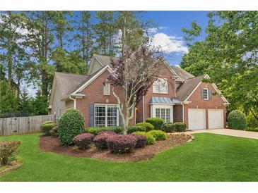 Charming two-story brick home with a well-manicured lawn and mature landscaping at 2720 Stillwater Lake Ln, Marietta, GA 30066