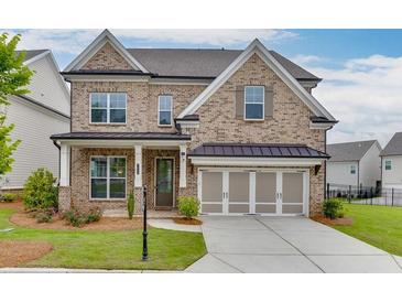Charming brick two-story home featuring a two-car garage, landscaped lawn, and covered front porch entrance at 1459 Bennett Creek Ovlk, Suwanee, GA 30024