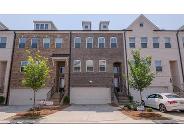 Charming brick townhome with a two-car garage and well-maintained landscaping in a private residence at 2247 Pink Hawthorn Dr, Buford, GA 30518