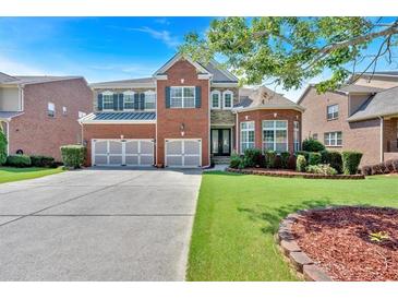 Beautiful brick home featuring a three-car garage and well-manicured lawn at 3819 Courson St, Marietta, GA 30066