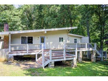 Charming home featuring an elevated deck and a serene, wooded backdrop at 504 N Little Victoria Rd, Woodstock, GA 30189