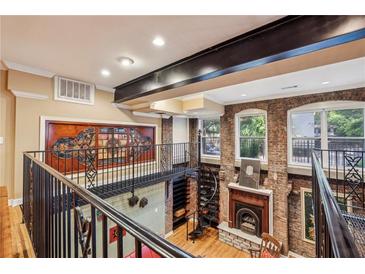 Unique living room featuring exposed brick, spiral staircase, and a mezzanine overlooking the space at 685 Argonne Ne Ave # 15, Atlanta, GA 30308