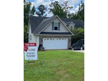 Charming home featuring a two-car garage and a well-maintained front yard at 413 W Wind Dr, Villa Rica, GA 30180