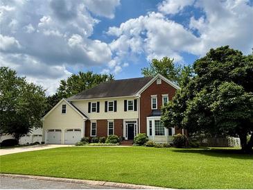 Traditional two-story home featuring a brick and siding exterior, three-car garage, and a well-manicured front lawn at 881 Park Manor Nw Ct, Marietta, GA 30064