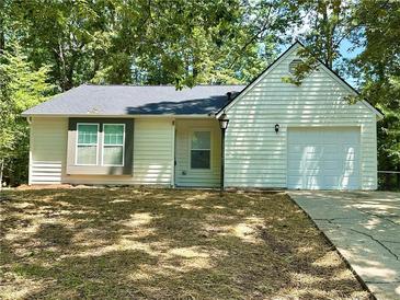 Charming one-story home with light siding, dark roof, attached garage, and a well-manicured front yard at 850 Greenhedge Dr, Stone Mountain, GA 30088