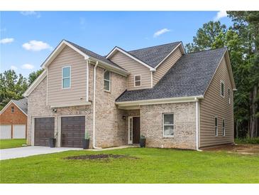 Inviting two-story home featuring a two-car garage and a mix of brick and siding at 3405 Summer Brooke Way, Union City, GA 30291