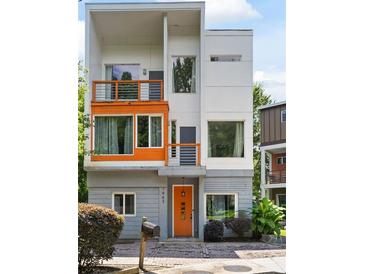 Modern three-story home showcasing a contemporary design with orange accents and balconies at 1463 Macklone Ne St, Atlanta, GA 30307