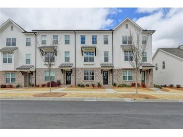 Charming townhomes featuring painted brick, private entries, and manicured front yards offer inviting curb appeal at 1273 Harvest Park Ln, Suwanee, GA 30024