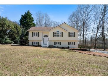 Charming two-story home with light yellow siding, dark shutters, and a well-maintained front lawn at 4312 Daniel Dr, Winston, GA 30187