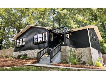 Charming home featuring dark exterior, stone foundation, pergola, and inviting front steps at 706 Powder Springs Se St, Smyrna, GA 30080