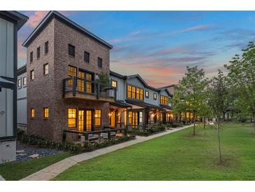 Stunning townhome exterior with brick and siding, balconies, and a well-maintained lawn at dusk at 933 Willingham Dr # 9, Hapeville, GA 30354