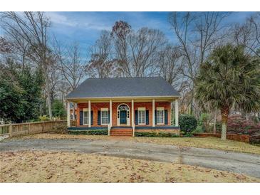 Charming brick home featuring a covered front porch, inviting curb appeal, and traditional architectural details at 1216 Valley Dr, Conyers, GA 30012