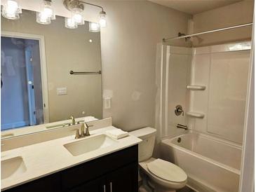 Bright bathroom featuring a double sink vanity, illuminated mirror, and a shower-tub combo with white tile surround at 305 Melanie Ct, Bowdon, GA 30108