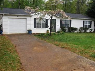 Charming single-story home with a well-manicured lawn and blossoming tree in the front yard at 218 Whispering Pine Circle Ne Cir, White, GA 30184