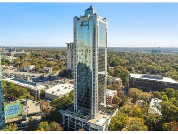 A modern skyscraper with reflective glass, nestled in a vibrant green landscape and neighborhood views at 2828 Peachtree Nw Rd # 1502, Atlanta, GA 30305