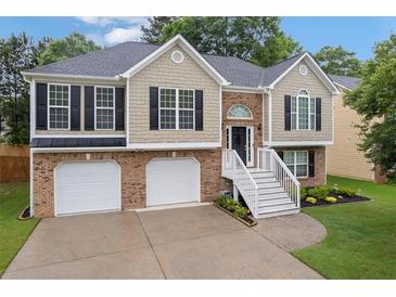 Charming split-level home featuring a brick facade, two-car garage, and welcoming front staircase at 4040 Brightmore Dr, Austell, GA 30106