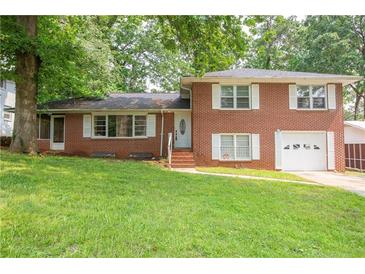 Charming two-story red brick home with white shutters and a well-manicured lawn at 1558 Boulderwoods Se Dr, Atlanta, GA 30316