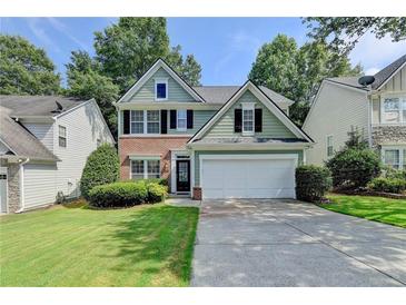 Charming two-story home featuring a brick and siding exterior with a well-manicured lawn and two-car garage at 335 Pintail Ct, Suwanee, GA 30024