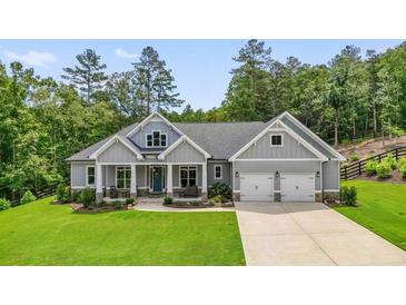 Charming, single-story home with a two-car garage, gray siding, covered porch, and manicured lawn at 287 Flower Farm Dr, Acworth, GA 30101