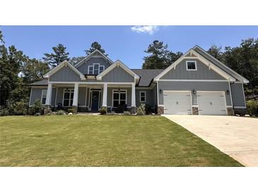 Charming craftsman-style home with a well-manicured lawn, stone accents, and a two-car garage at 287 Flower Farm Dr, Acworth, GA 30101