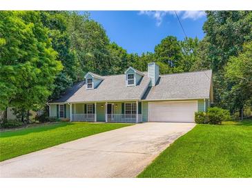 Charming single-Gathering home featuring a manicured lawn, two-car garage, and inviting front porch at 230 Belmont Trl, Covington, GA 30016