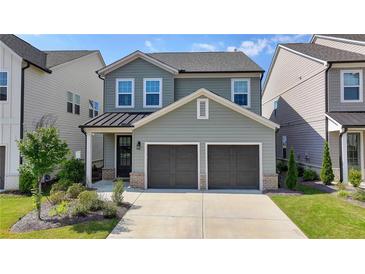 Charming two-story home with a two-car garage and beautifully landscaped front yard under a bright blue sky at 4583 Roskin St, Duluth, GA 30097
