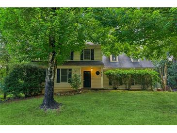 Charming two-story home with lush green lawn and mature trees offering shade at 658 Slew Ave, Lawrenceville, GA 30043