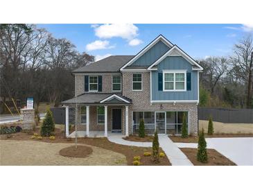 Charming two-story brick home with a covered porch and professionally landscaped front yard at 113 Maplewood Ln, Conyers, GA 30094