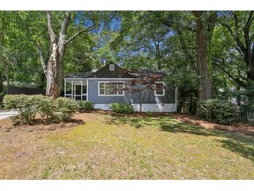 Charming single-story home featuring a screened front porch and lush, mature landscaping at 2130 Main Nw St, Atlanta, GA 30318