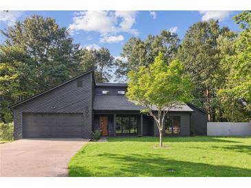 Contemporary home featuring a modern design, dark wood facade, manicured lawn, and attached two-car garage at 600 Applewood Nw Ln, Marietta, GA 30064