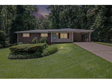 Charming brick home featuring a well-manicured lawn and covered carport at 4051 Dixie Ln, Douglasville, GA 30135