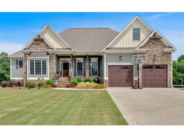 Charming home featuring a well-manicured lawn, stone accents, and a two-car garage with a basketball hoop at 101 River Walk Pkwy, Euharlee, GA 30145
