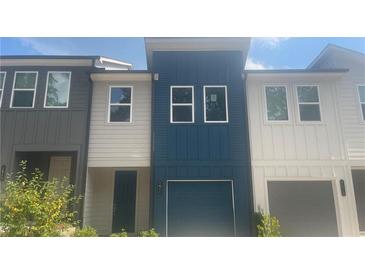 Townhome exterior with blue and white siding, a one-car garage, and a front door at 1615 Gunnin Nw Trce, Atlanta, GA 30318