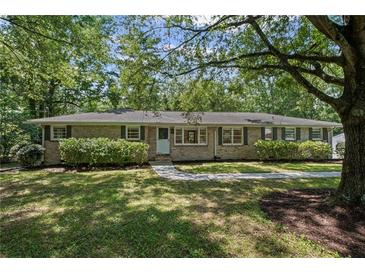Charming brick ranch home with a well-manicured lawn, mature trees, and inviting walkway at 119 Walker Nw Rd, Cartersville, GA 30121