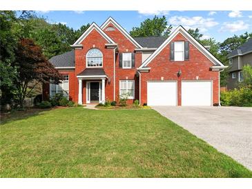 Charming brick two-story home featuring an attached two-car garage and well-manicured lawn at 5054 Kingsbridge Pass, Powder Springs, GA 30127