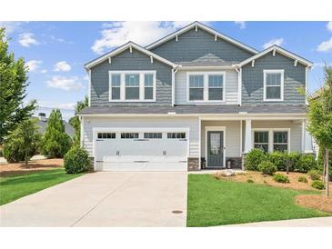 Charming two-story home with a well-manicured lawn, two-car garage, and stylish gray and white color scheme at 515 Cobblestone Ct, Canton, GA 30115