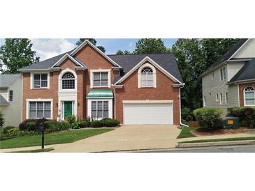 Beautiful brick home with manicured lawn, attached two car garage, and mature trees at 2905 Olde Town Park Dr, Norcross, GA 30071