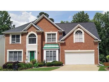 Traditional brick two-story home with a two-car garage and manicured lawn, great curb appeal at 2905 Olde Town Park Dr, Norcross, GA 30071
